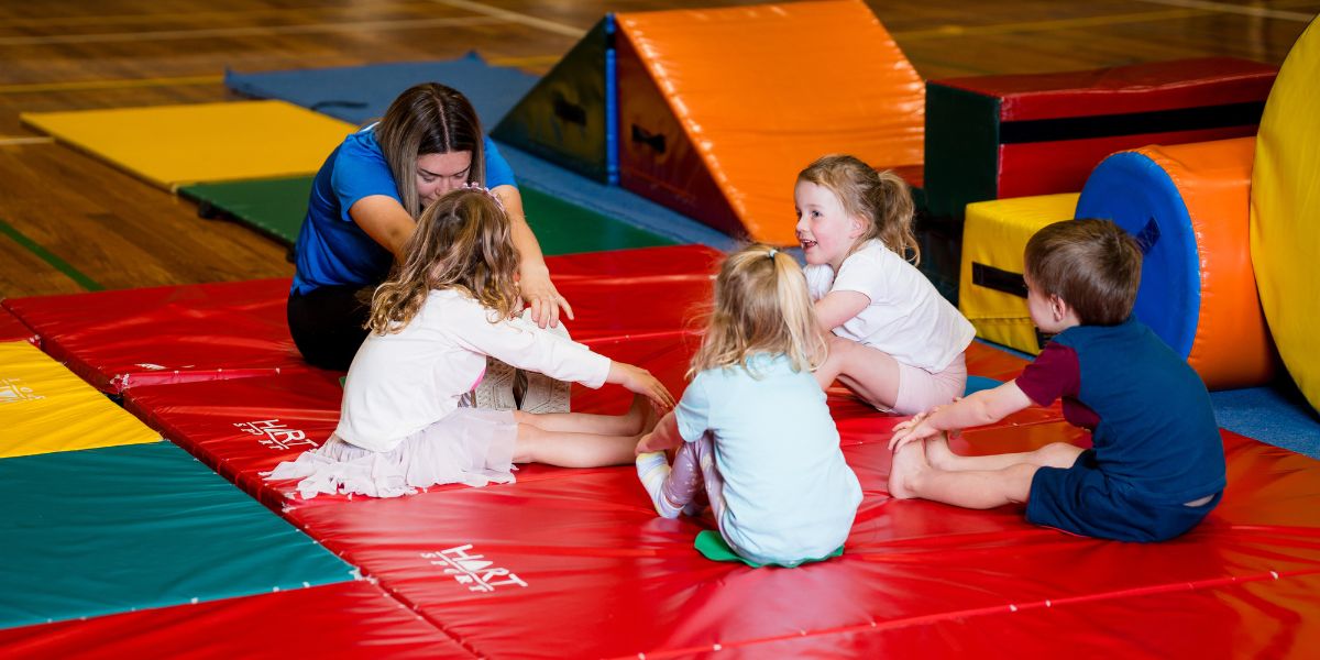 A group of children stretching with an instructor during a pre-school gymnastics class at Christchurch Recreation and Sport centre. 