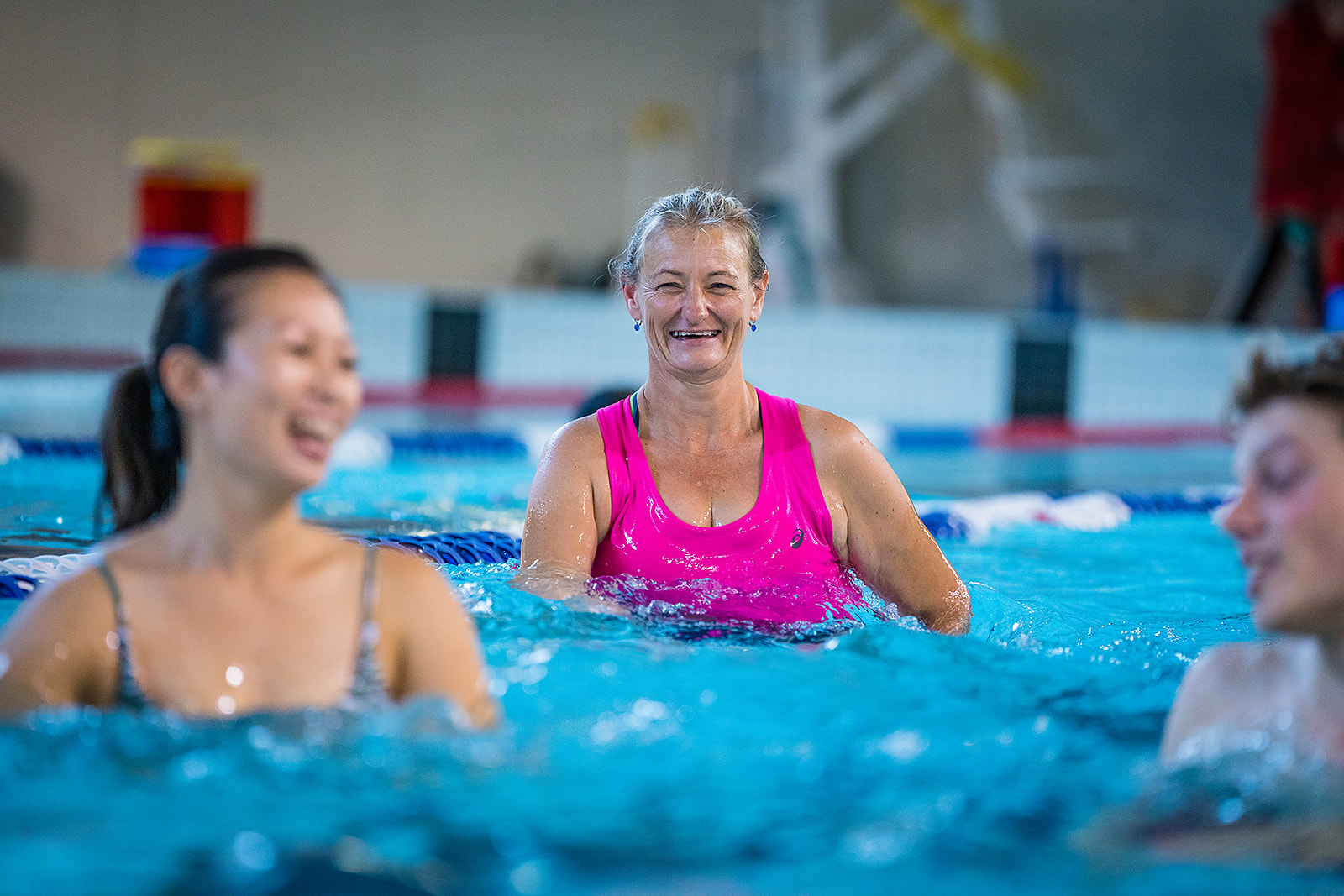 Two women laughing in the Matatiki pool while participating in an Aqua class. 